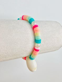 a close up of a bracelet on a person's arm with a white background