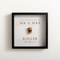 a black frame with a cork in it that says our first toast as mr and mrs