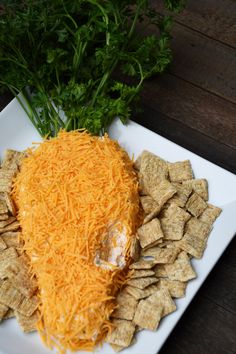 a plate with crackers, cheese and parsley on it