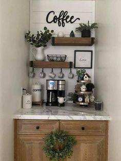 the coffee bar is decorated with greenery and pictures on the wall above it, along with two wooden shelves