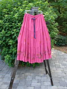 Barclay Linen Drawstring Ruffle Skirt Daisy Fence Flamingo Size 2 hanging on a rack, showcasing its full contrasting drawstring waistline, horizontal seams, A-line shape, and billowy flare with fringe edges. Spring Gatherings Tiered Skirt, Pink Tiered Bohemian Bottoms, Daisy Theme, Ruffle Skirt, Summer Collection, Mint Condition, Fence, Flamingo, Daisy