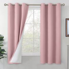 a pink curtain hanging in front of a window with a white drape on it