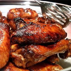 some chicken wings are on a plate with a fork