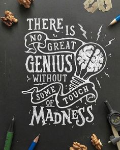 there is no great genius without some touch of madness written on a chalkboard with pencils and crayons