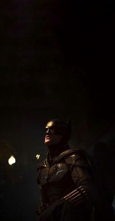 a man dressed as batman standing in the dark