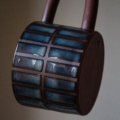 a close up of a brown and blue object hanging from a hook on a wall