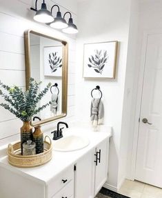 a white bathroom with two sinks and mirrors