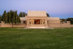 a large house sitting on top of a lush green field