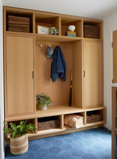 a room with some wooden cabinets and baskets on the wall next to a blue floor