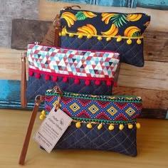 three colorful clutches are sitting on a table