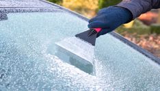 a person is cleaning the windshield of a car with a sponge and rag on it