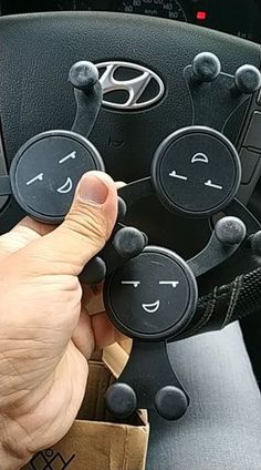 a person is holding the steering wheel knobs in their hand and pressing buttons to turn on or off