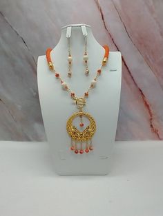 "Handmade and designed by me-one of a kind necklace set-orange seed bead crocheted rope necklace-23\" long-2 1/2\" gold tone Bali style medallion focal with 1\" long chain dangles and sea sediment jasper beads-glass beads-jasper beads-2 3/4\" long matching dangle earrings-gold tone toggle clasp in front-long-gold tone findings. This beautiful necklace set would be a great addition to your summer wardrobe! The necklace is easy on because of the toggle clasp is in the front." Bali Style, Bead Crochet Rope, Crochet Rope, Earrings Pendant, Necklace Beaded, Handcrafted Necklace, Rope Necklace, Jasper Beads, Bead Crochet