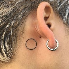 an ear with a circle tattoo on it