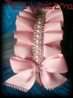 a close up of a pink bow with pearls