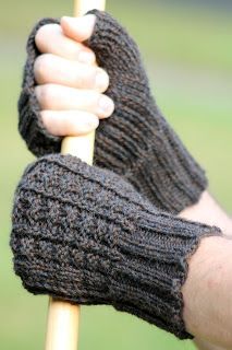 a person holding on to a stick with their arm wrapped in knitted mitts