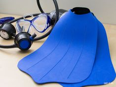 a pair of scuba fins and snorkels are sitting on a table next to a diving mask