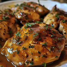 a plate with chicken covered in gravy and garnish