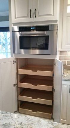 an oven built into the side of a cabinet in a kitchen with marble counter tops