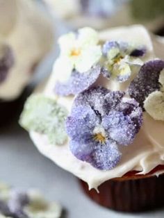 cupcakes with frosting and purple flowers on top