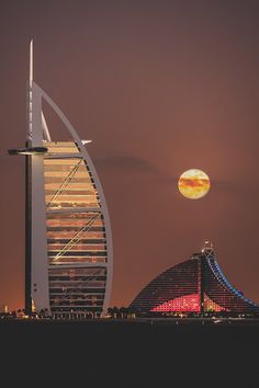 the moon is setting over burj al arab city