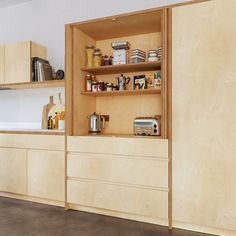 a kitchen with wooden cabinets and shelves filled with spices, condiments and other items