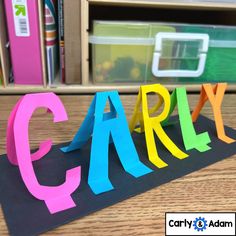 the word early spelled with colored paper on top of a book shelf in front of a bookshelf