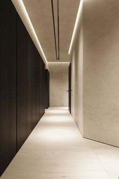 an empty hallway is lit up by recessed lighting and wood paneling on the walls