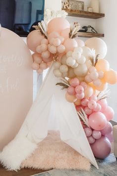 a teepee tent is decorated with balloons and flowers