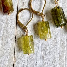 Let your inner Earth Goddess shine through with these lovely green peridot crystals. Simple enough for everyday but also powerful healers and elegant in an earthy, woodsy way. They hang from simple leverback ear wires in your choice of brass or gold fill. Each pair of these 100% natural stones are unique and ready to gift to that someone special. *The color ranges in these natural stones but all fall pretty close to the colors in the photos. Choose which color suits you best from the drop down m Inner Earth, Raw Crystal Earrings, 16th Wedding Anniversary, Raw Peridot, Earth Goddess, Peridot Crystal, Peridot Jewelry, Peridot Earrings, Tourmaline Earrings