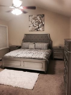 a bed room with a neatly made bed and dressers