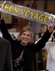 a woman holding up a sign with the words bon voyage on it