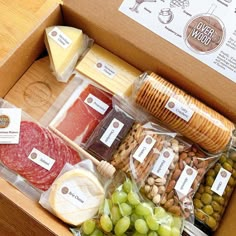 an open box filled with different types of cheeses and meats, including salami