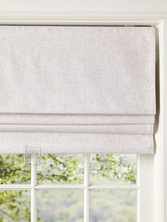 a window with a white roman blind in front of it