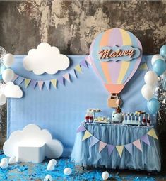 a blue table topped with cake and balloons