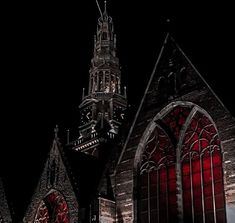 an old church with stained glass windows and a clock tower in the background at night