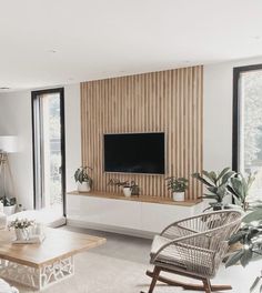 a living room filled with furniture and a flat screen tv mounted on a wall above a fireplace