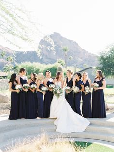 a bride and her bridal party in front of the mountains