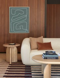 a living room with wood paneling and white couches, coffee table and rug