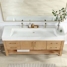 a bathroom sink sitting under a mirror next to a wooden cabinet and white counter top