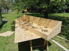 a wooden table sitting on top of a lush green field