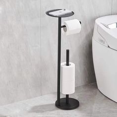 a bathroom with a toilet and a roll of toilet paper on the stand next to it