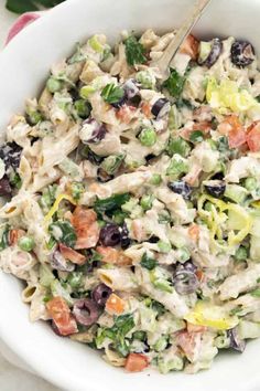 a white bowl filled with pasta salad on top of a table