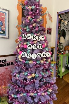 a purple christmas tree with merry and bright decorations