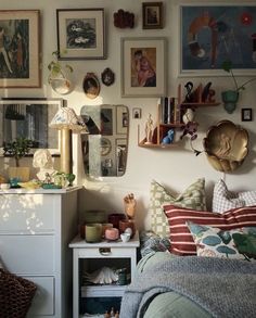 a bed room with a neatly made bed and lots of pictures on the wall above it