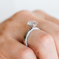 a woman's hand with a diamond ring on it