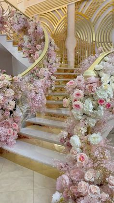 the staircase is decorated with pink flowers and gold railings