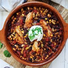 a bowl filled with chicken, beans and sour cream