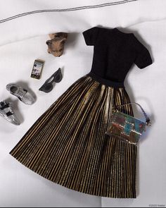 a woman's dress and shoes are laid out on a bed