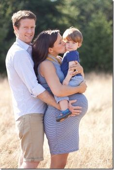 a man, woman and child are standing in a field